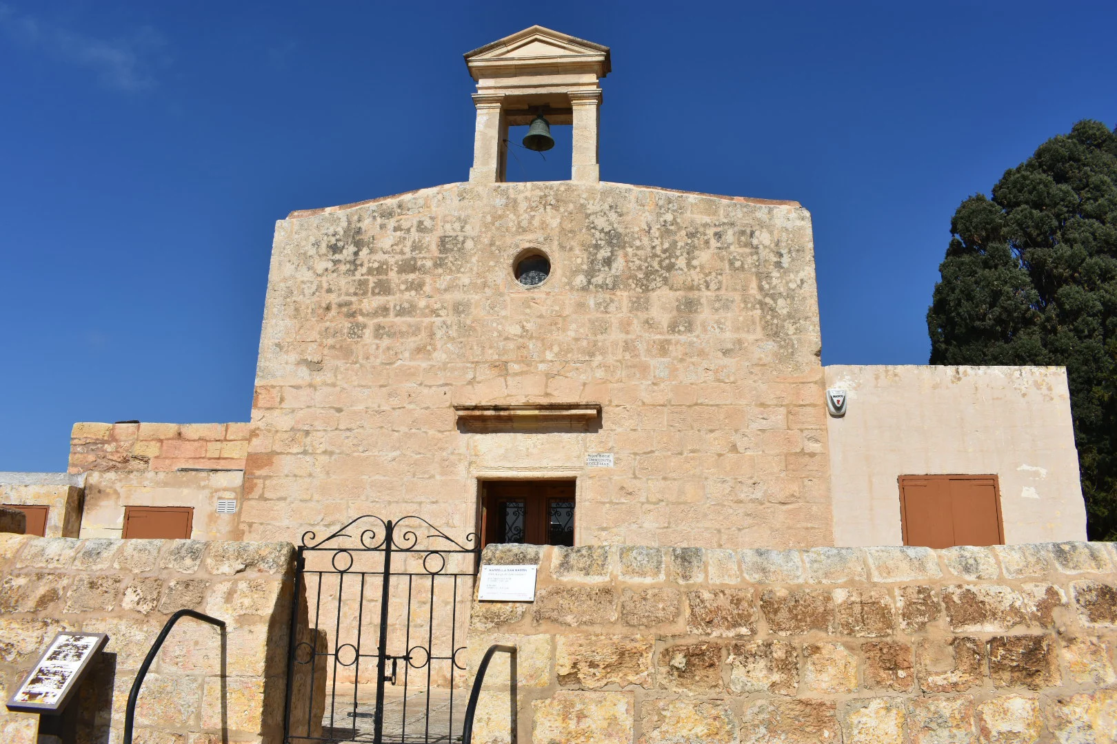 The stone facade and bell of St Martin Church in Baħrija, Malta