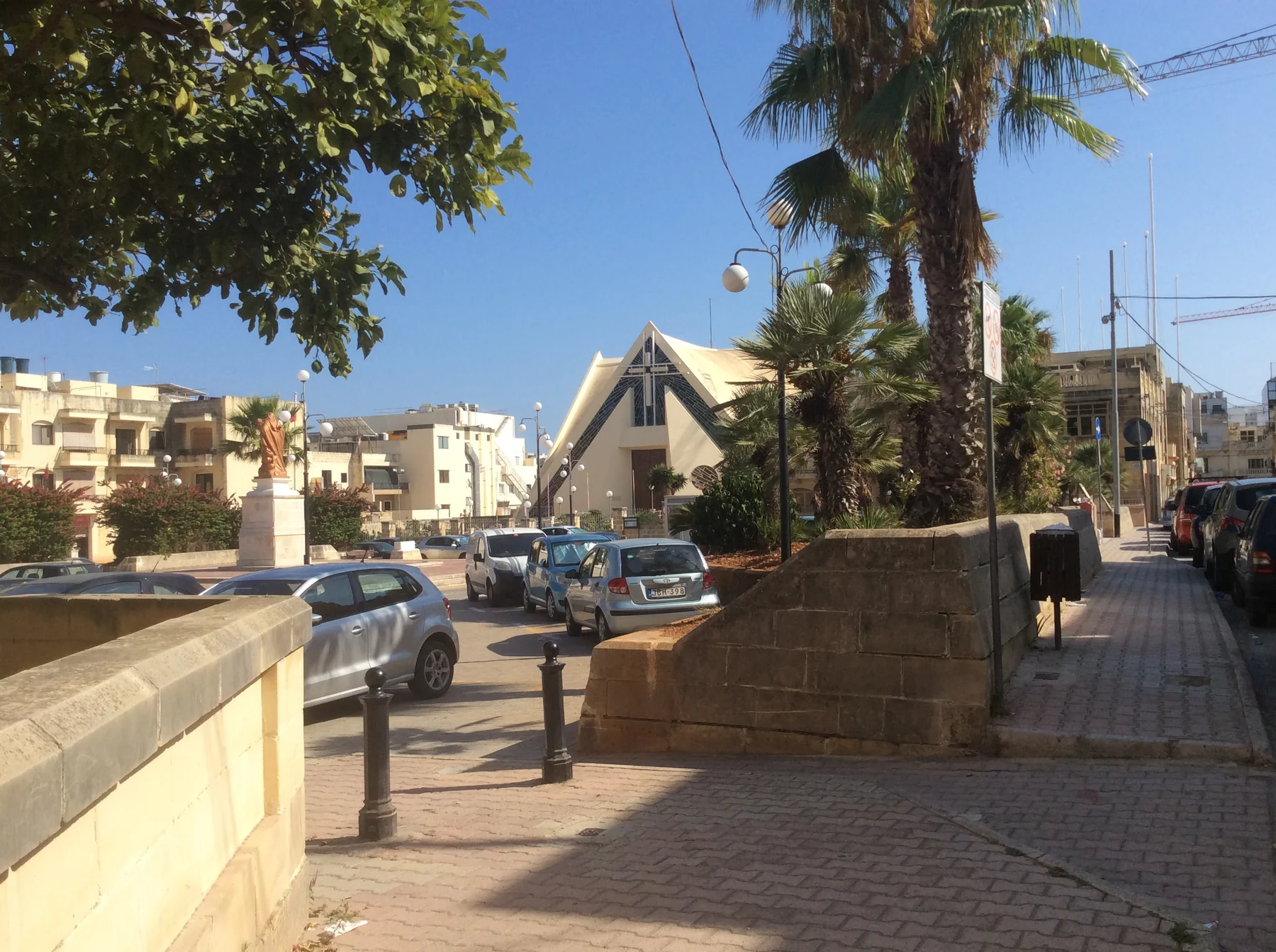 Modern parish church, surrounding homes and street edge in Il-Fgura, Malta
