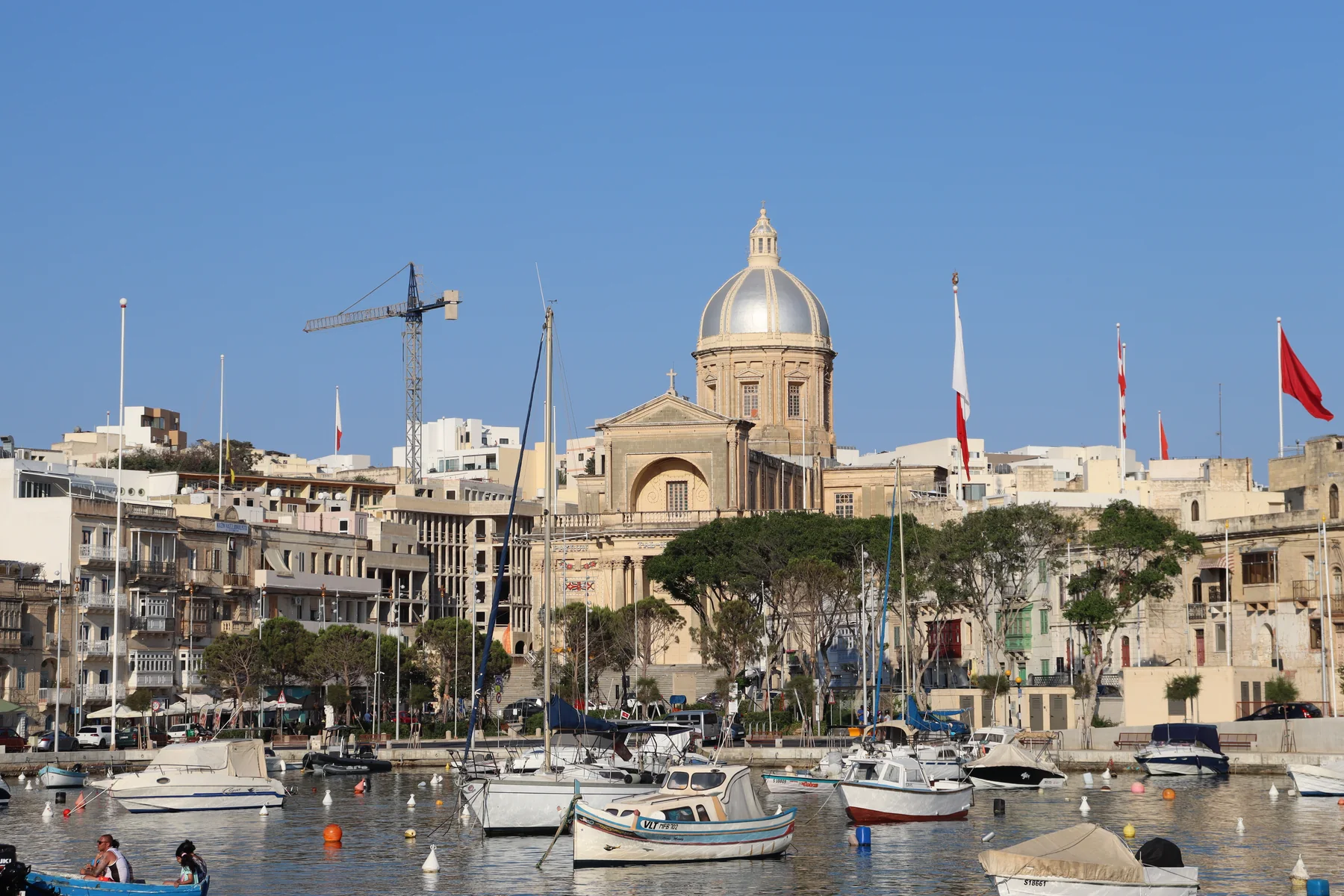 Kalkara parish church, waterfront buildings and moored boats across Kalkara Creek