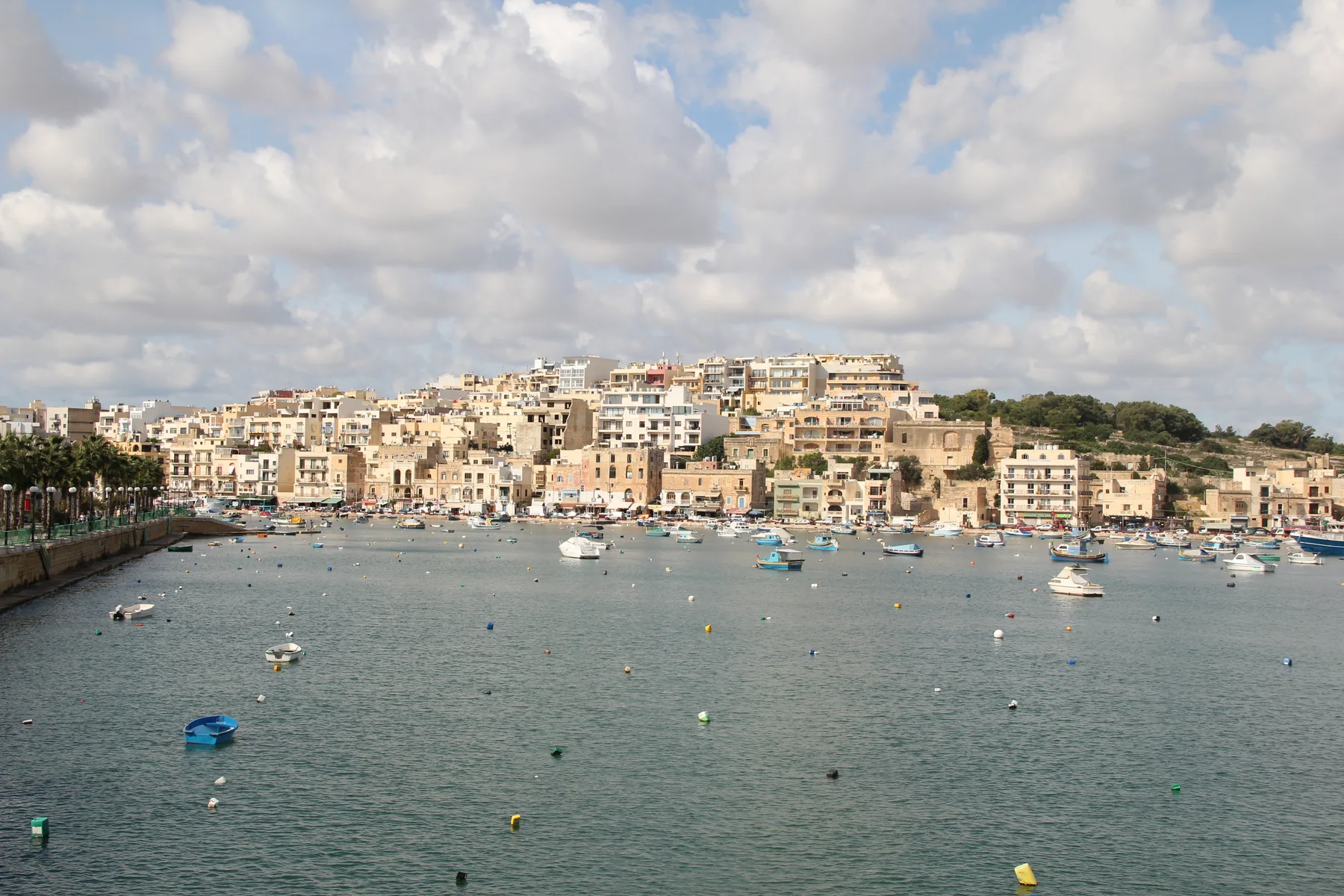 Marsaskala harbour, promenade, small boats and hillside homes in October 2012
