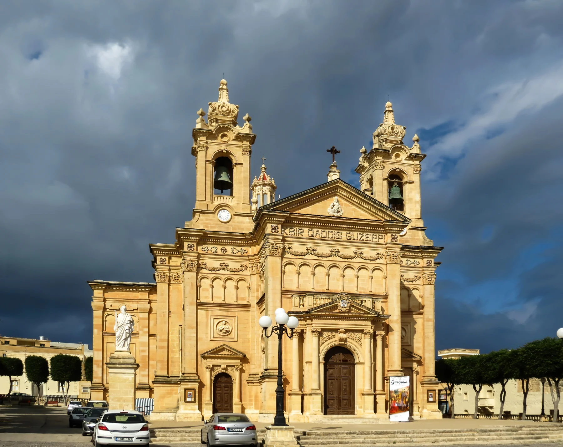 Parish church of the Immaculate Conception and Saint Joseph in Il-Qala, Gozo, beneath a dark clouded sky