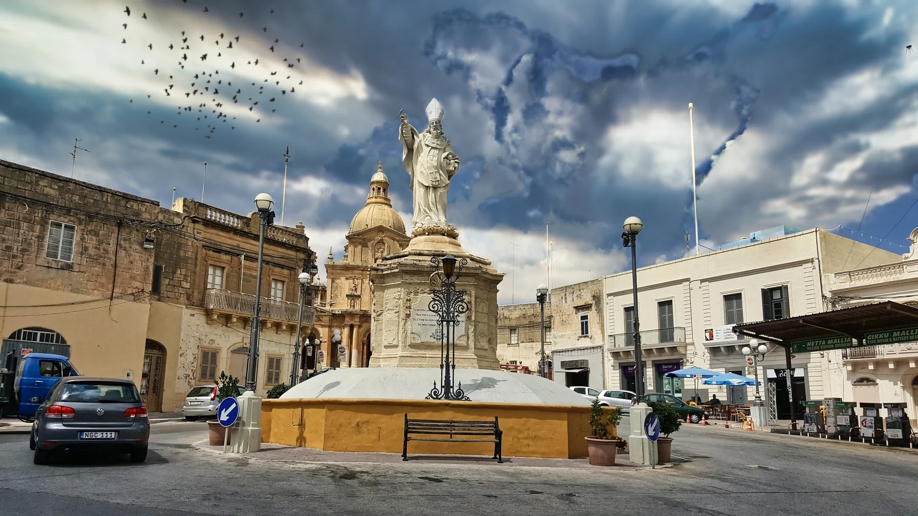 Statue of Saint Nicholas in Pjazza San Nikola, Siġġiewi, with the parish church dome and surrounding street frontage